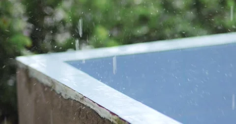 Raindrops splashing on a cement basin edge with a blurred green background... Stock Footage 341558174