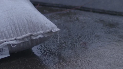 Raindrops splashing onto wet concrete surface in slow motion. Stock Footage 86569607