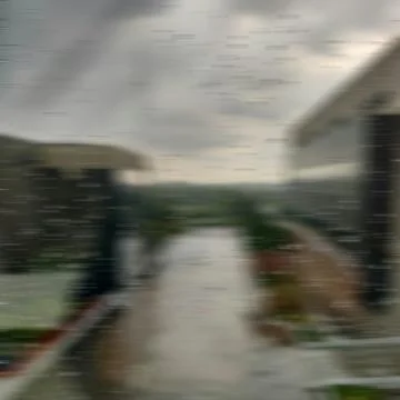Raindrops streak across a window blurring the view of a building and the surr Stock Photos