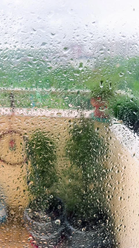 Raindrops stream down the glass surface on a stormy day.  Видео 338241201