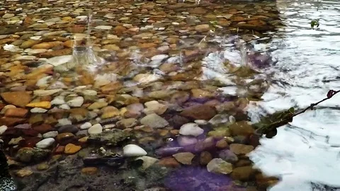 Raindrops in a stream with river rocks - 1080 slow Stock Footage 77656507