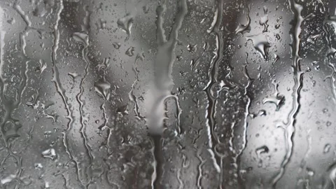 Raindrops streaming down a glass window close up macro view Stock Footage 340832576