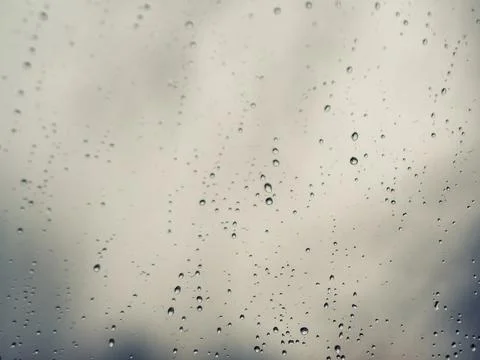 .Raindrops on the surface of window glass with a blurred background. Stock Photos