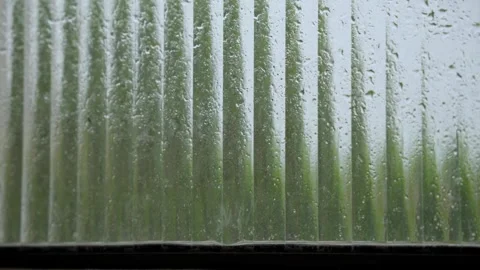 Raindrops on a textured window, condensation on a window reflection Stockbeeldmateriaal 329528760