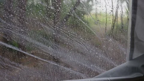 Raindrops on Transparent Tent Window with Blurred Forest Background Stock Footage 341990033