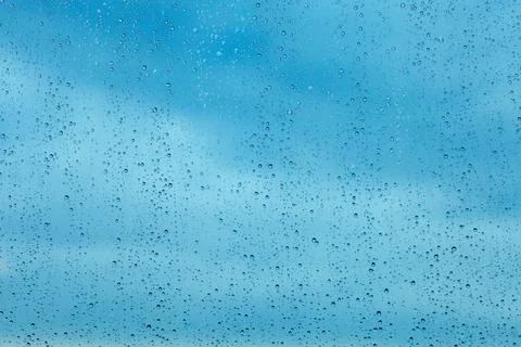 Raindrops on the transparent window pane. Background of raindrops. Stock Photos