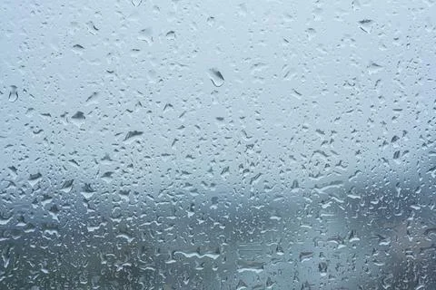 Raindrops on the transparent window pane in rainy weather. Stock Photos