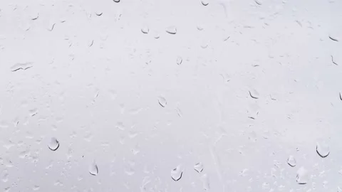 Raindrops on a transparent window run down a vertical surface. Stock Footage 166233029