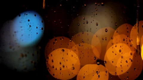 Raindrops trickle down window glass with colorful city bokeh Video stock 333830660