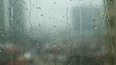 Raindrops trickling down on window during heavy rain Stock Footage 129485582