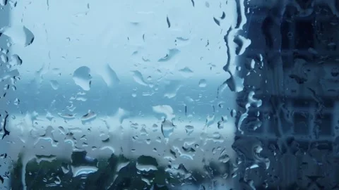 Raindrops Trickling Down a Window Overlooking the City on a Gloomy Afternoon Stock Footage 262464869