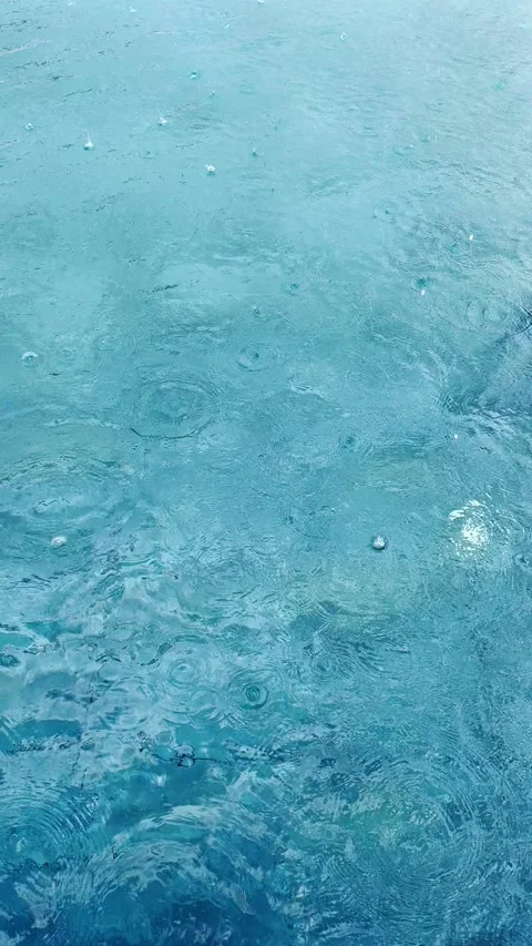 Raindrops on water surface looping vertical video Stock Footage 337657704