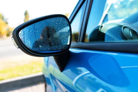 Raindrops on the wet side-view mirror. rainy weather and car wash Stock Photos