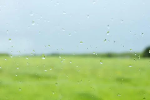 Raindrops on a window and blurred landscape background Stock Photos