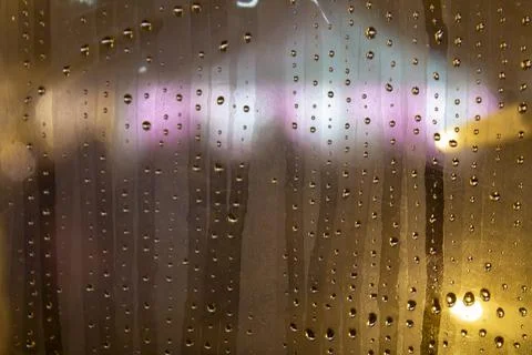 Raindrops on window with blurred city lights Fotos de archivo
