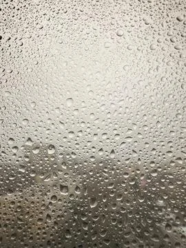Raindrops on a window. Blurred cityscape in the background Stock Photos