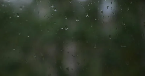 Raindrops on a window with blurred nature background Stock Footage 341441264