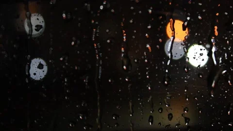 Raindrops on the window,  blurry view of city lights at night Stock Footage 164719055