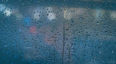 Raindrops on the window of the car. Abstract blur bokeh of traffic and car .. Stock Photos