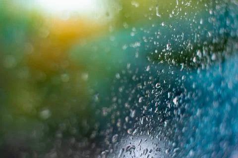 Raindrops on the window. Colored background with wet glass. Stock-Fotos