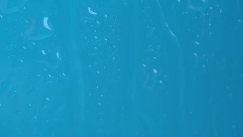 Raindrops on the window dripping down on blue background. Macro Stock Footage 271148223