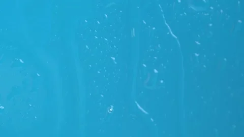 Raindrops on the window dripping down on blue background. Macro Stock Footage 274547537