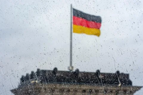 Raindrops on the window with German flag in the background Stock-Fotos
