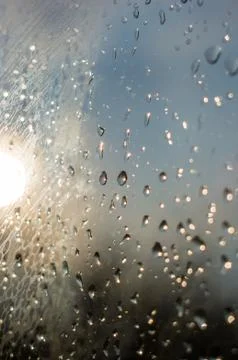 Raindrops on window glass on background of cloudy sky Foto stock