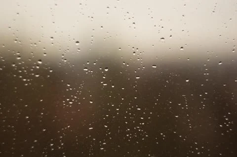 Raindrops on window glass on background of cloudy sky Stock Photos