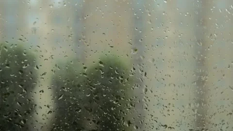 Raindrops on window glass with blurred house in background Stock Footage 339649973