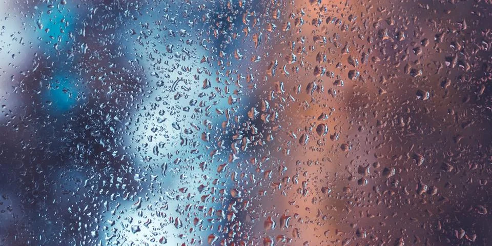 Raindrops on window glass. Selective focus, bokeh. Rainy city background. Aut Stock Photos