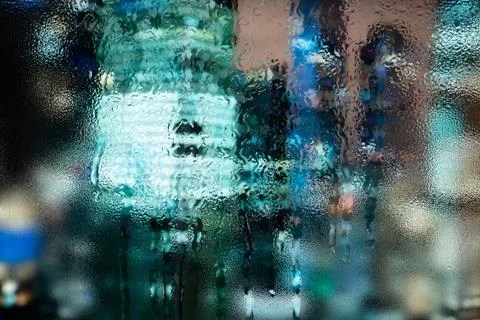 Raindrops on window glass. Selective focus. Rainy city background. Stock Photos