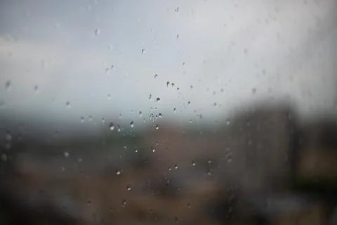 Raindrops on a window, gray sky at day light Stock Photos