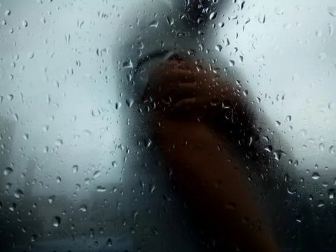 Raindrops on a window with a human texture Stock Photos