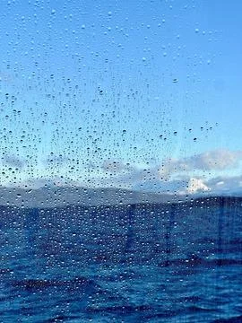 Raindrops on a window overlooking the sea Stock Photos