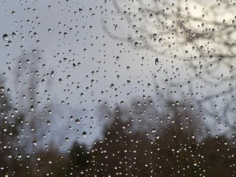 Raindrops on a window pane, on a background of heavily cloudy sky, Stock Photos