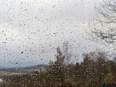 Raindrops on a window pane, on a background of heavily cloudy sky, Foto stock