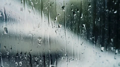 Raindrops on a window pane with blurred background Stock Footage 341924465