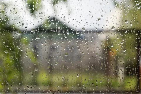 Raindrops on window pane. Blurred background outside the window in the rain. Stock Photos