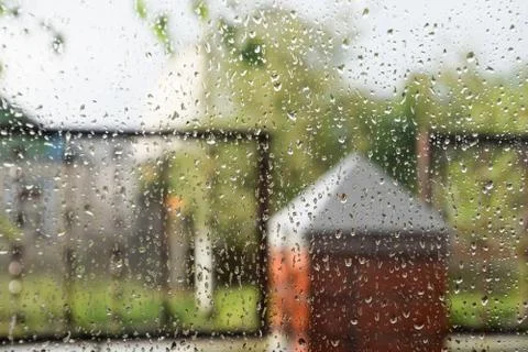 Raindrops on window pane. Blurred background outside the window in the rain. Stock Photos
