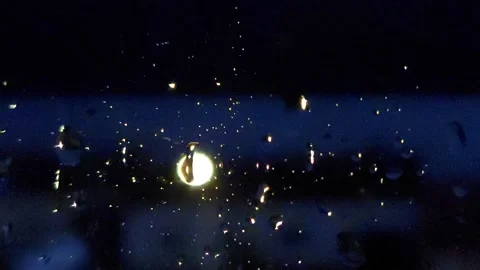 Raindrops on window pane at night with blurry street light in background Stock Footage 335074800