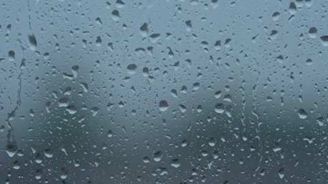 Raindrops on a window pane, overcast day, 8K Stock Footage 338252636