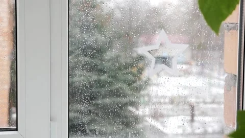 Raindrops on the window pane, white paper star on the wet window Stock Footage 171654625