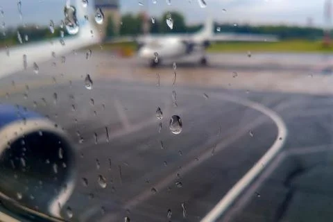 Raindrops on the window of the porthole, the plane is preparing to take off i Stock Photos