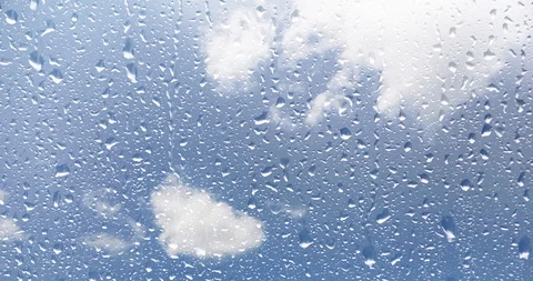 Raindrops on window with sky background Stock Footage 98999825