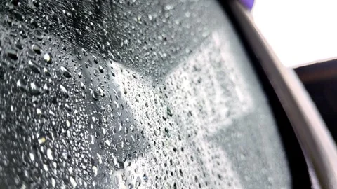 Raindrops on a Window Surface Capturing a Clear Reflection of the Outdoors Stock Footage 304431697