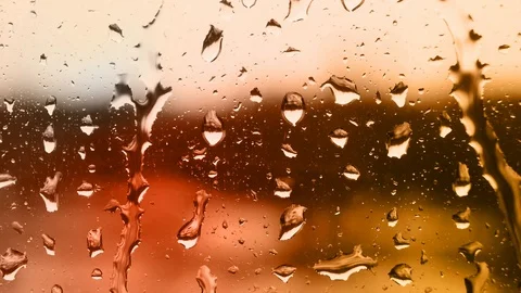 Raindrops on the window with warm lighting Stock Footage 100023203