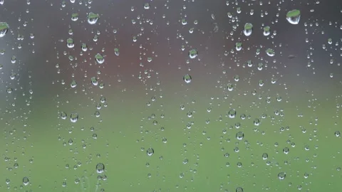 Raindrops on window while blurred cars pass in background with lights useful  Stock Footage 221478162