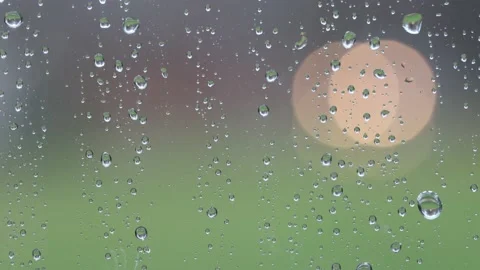 Raindrops on window while blurred cars pass in background with lights useful  Stock Footage 221478169