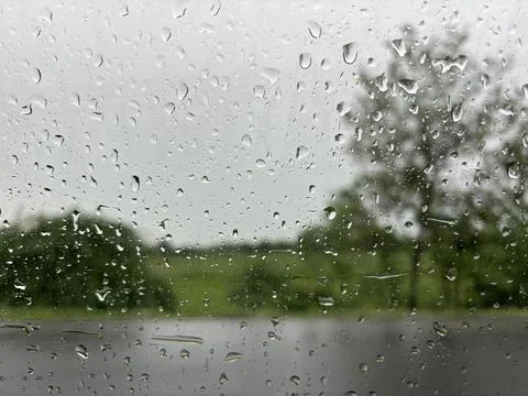 Raindrops on a Windowpane, Blurred Trees in the Background Stock Photos